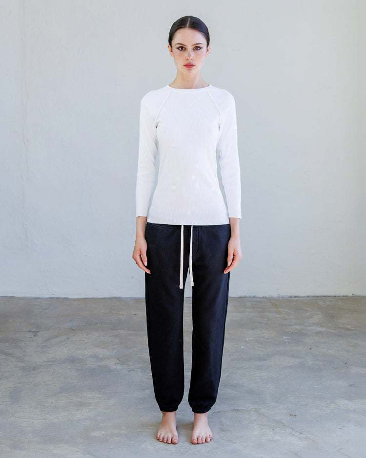 Aria Rib Raglan Tee- Pearl worn by a woman with black pants, showcasing a fitted long sleeve design.