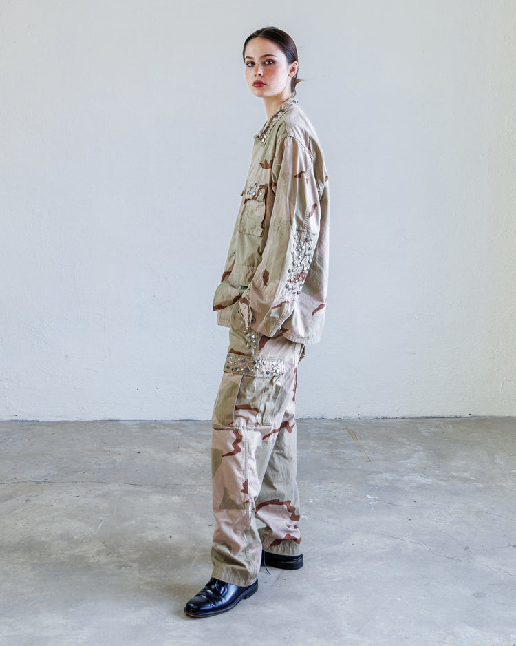 Scout Studded Twill Unisex Cargo Pant - Desert worn by model in an industrial space showcasing its military-inspired design.