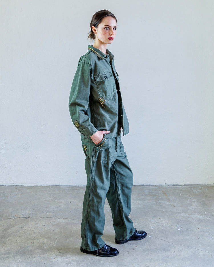Wells Studded Sateen Women's Baker Pant - Army worn by model in an industrial setting, showcasing unique military-inspired design.
