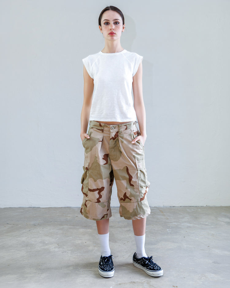 Model wearing Jesse Twill Unisex Cargo Short - Desert with a white top and sneakers, showcasing military-inspired design.