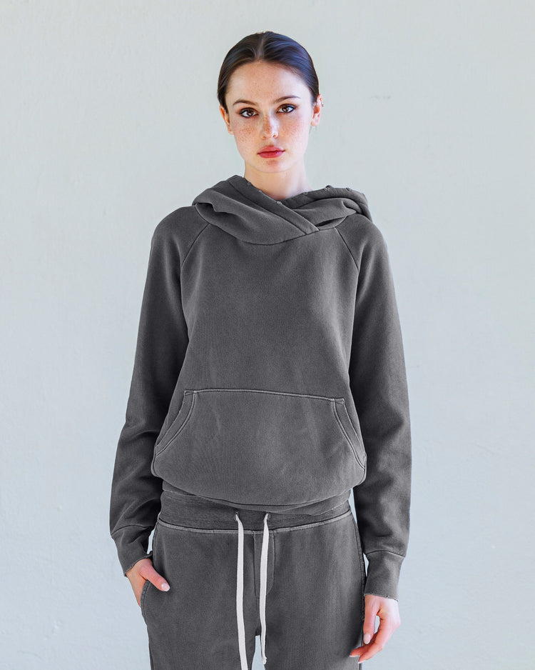 Lisse Loop Terry Hoodie - Aged Black worn by a model, featuring oversized hood and front pocket, in distressed finish.