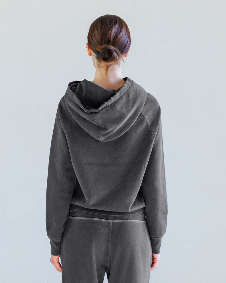 Woman wearing Lisse Loop Terry Hoodie - Aged Black from the back, showcasing oversized hood and slim fit.