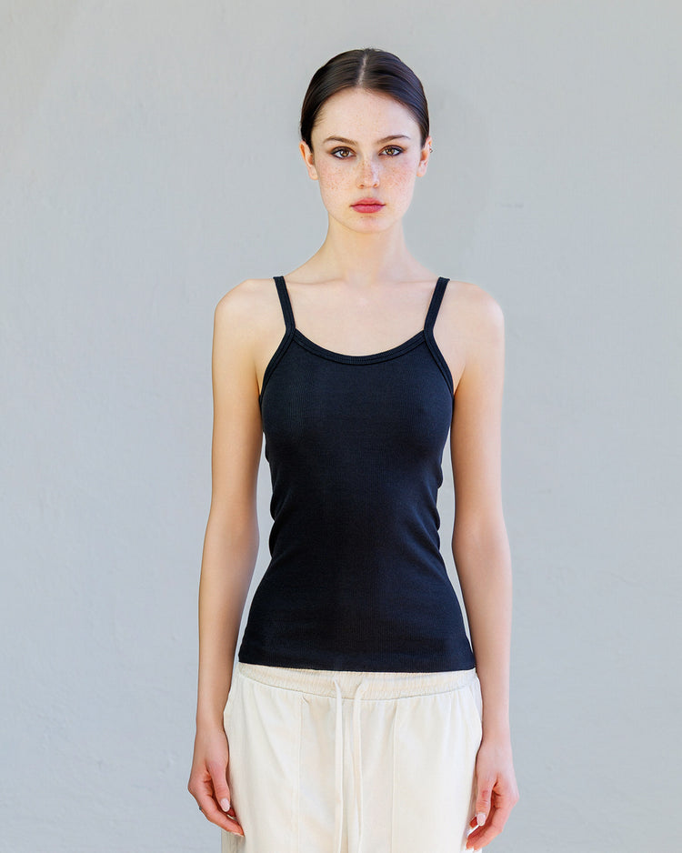 Kai Rib Cami Tank - Black worn by a model, showcasing its slim fit and delicate spaghetti straps.