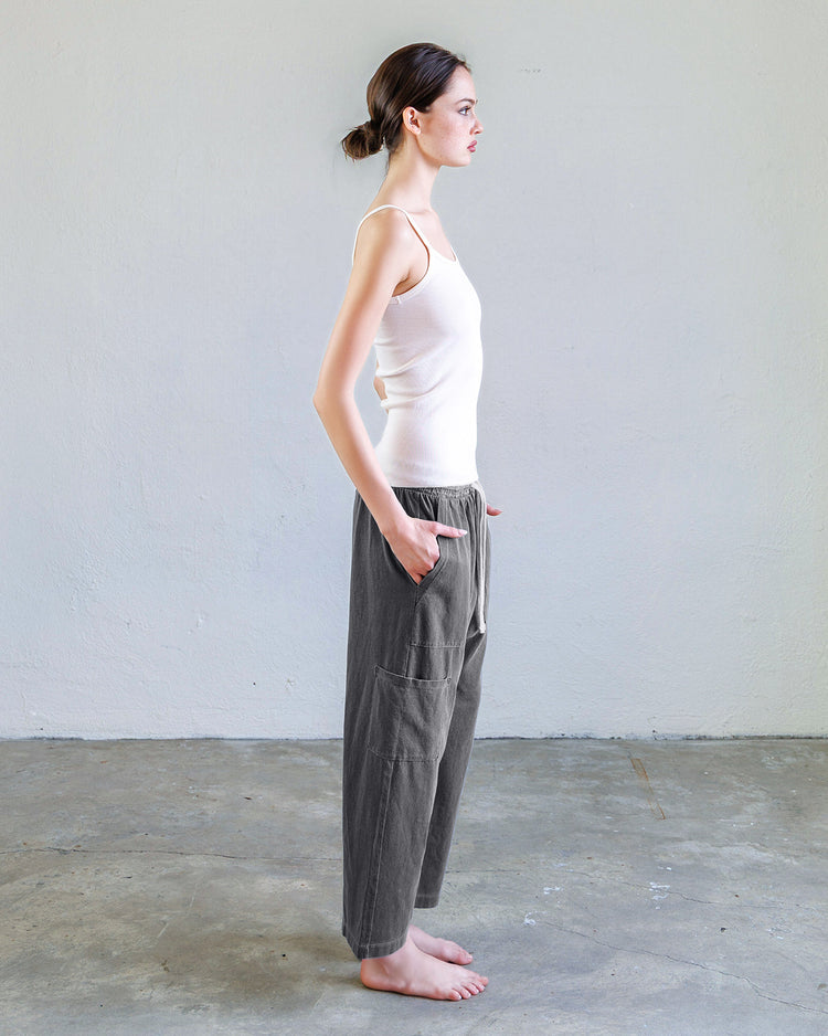Woman modeling Kai Rib Cami Tank - Pearl with relaxed pants in a minimalist setting.